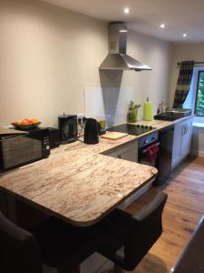 a kitchen with a large wooden table in a kitchen at Winwood Apartment in Holmfirth