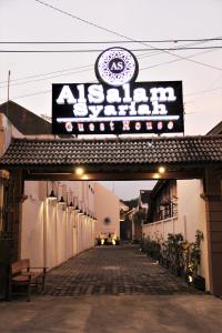 uma entrada para um edifício com uma placa em Alsalam Syariah Guesthouse em Surakarta