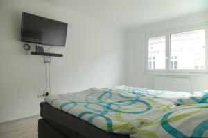 Schlafzimmer mit einem Bett und einem Flachbild-TV in der Unterkunft Viennaflats - Apartment Prater in Wien