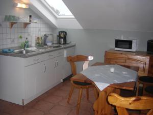 a kitchen with a sink and a table with chairs at Lindenblüte in Eggstedt