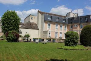 桑斯The Originals City, Archotel, Sens的一座前面有草坪的大楼