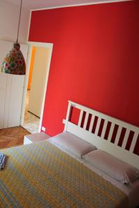 - une chambre avec un mur rouge et un lit dans l'établissement Youhome Millelire Apartment, à Milan