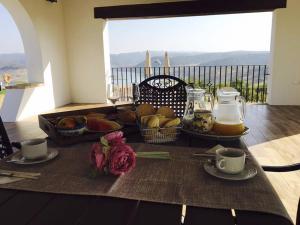 a table with food and flowers on a table with a view at Casas de Alisné in Almodóvar del Río