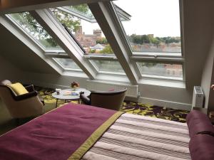 a bedroom with a large bed and two windows at Durham Cathedral View in Durham