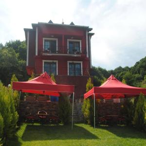ein rotes Haus mit zwei roten Regenschirmen davor in der Unterkunft Ağva Heaven Hill Butik Otel in Agva