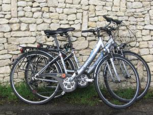 deux vélos garés à côté d'un mur de pierre dans l'établissement Les Chênes Bleus, à Sainte-Marie de Ré