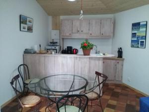 a kitchen with a glass table and chairs at Les Chênes Bleus in Sainte-Marie-de-Ré