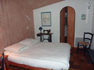 a bedroom with a bed and a table with a chair at Les Chênes Bleus in Sainte-Marie-de-Ré