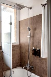 a shower in a bathroom with a tub at The Yard Zürich in Zurich