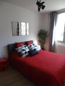 a bedroom with a red bed with pillows on it at Appartement HEMINGWAY in Avignon