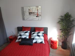 ein Schlafzimmer mit einem roten Bett mit schwarzen und weißen Kissen in der Unterkunft Appartements HEMINGWAY in Avignon