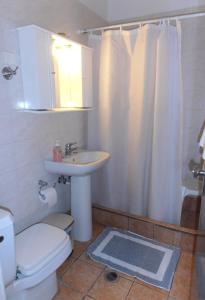 y baño con lavabo, aseo y ducha. en Hotel Bretagne, en Loutraki