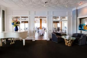 a dining room with a white piano and a table at Danfords Hotel & Marina in Port Jefferson Station