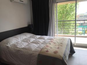 a bedroom with a bed and a large window at Departamento en Tigre con Pileta y cochera in Tigre +50 photos