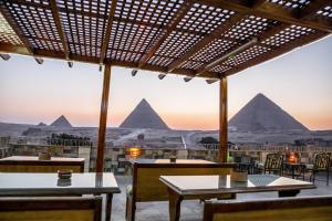 uma vista das pirâmides de um restaurante com mesas em Guardian Guest House no Cairo
