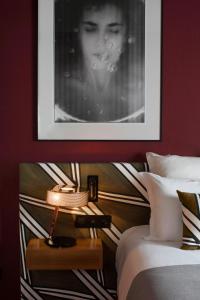 um quarto com uma fotografia e um candeeiro ao lado de uma cama em Hôtel Louvre Piemont em Paris