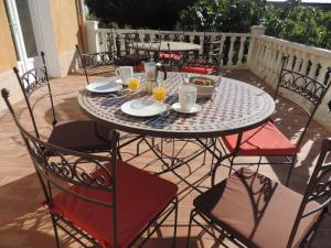 un tavolo con piatti, tazze e sedie su un patio di 1001 Ocres ad Apt
