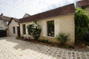 a small white house with a window and a patio at La Petite Madame in Moret-sur-Loing