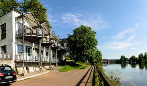 ハーメルンにあるWeserwohnung - Bootshaus Urlaub am Wasserの川の横の建物