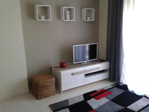 ein Wohnzimmer mit einem TV auf einem weißen Schrank in der Unterkunft Lovely 1 Bed Apartment - Vista das Ondas in Albufeira