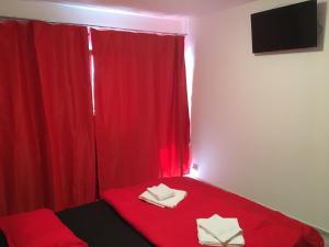 een kamer met een rood bed en een rood gordijn bij Jane House 2 in Boekarest