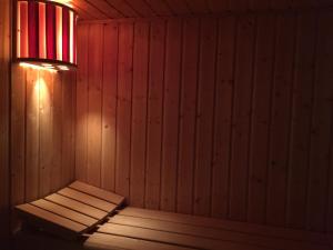 uma sauna de madeira com uma luz na parede em Le Clos du Gusquel em Plescop