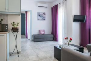 アギア・マリーナ・ネア・キドニアスにあるNikos Apartmentsの紫色のカーテンとソファ付きのリビングルーム