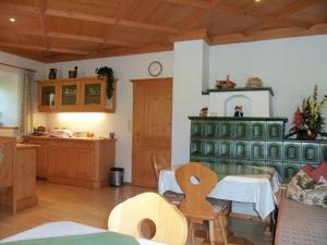 a living room with a green cabinet and a kitchen at Bauernhof Grieslehen in Leogang