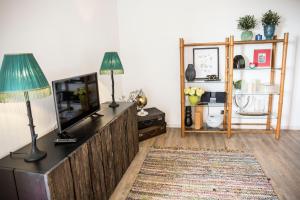 フンシャルにあるApartment Serrãoのリビングルーム(テレビ、ランプ付きテーブル付)