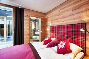 a bedroom with a large bed with red pillows at Alpenmaisonette Gipfelstürmer in Bramberg am Wildkogel