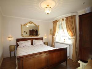 1 dormitorio con 1 cama grande y espejo en No.31 B&B im Rosengarten, en Kapellen-Drusweiler