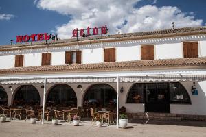 ein Hotel mit Tischen und Stühlen außerhalb in der Unterkunft Hotel Restaurante Setos in Motilla del Palancar