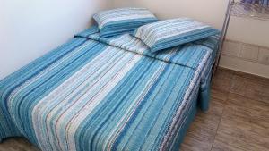 a blue bed with two pillows on top of it at Recanto do Dan - Praia Picarras- Beto Carrero in Piçarras