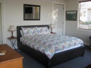 1 dormitorio con 1 cama, 2 mesas y 2 lámparas en Korohi Vineyard BnB en Blenheim