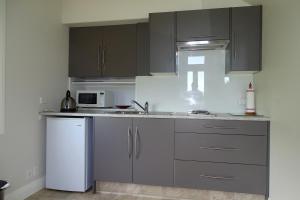 a kitchen with gray cabinets and a white refrigerator at Korohi Vineyard BnB in Blenheim