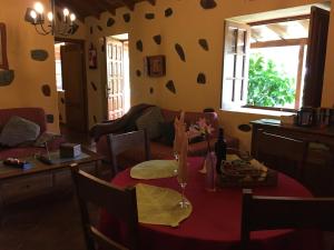 ein Wohnzimmer mit einem Tisch und einem roten Tischtuch in der Unterkunft Casa Rural El Rincón de Antonia in Agulo