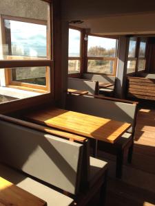 a room with a table and chairs and windows at Complejo Sakura in Villa Gesell