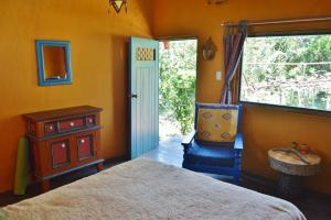 1 dormitorio con 1 cama, 1 silla y 1 ventana en Puka Wasi Posada en Tarapoto