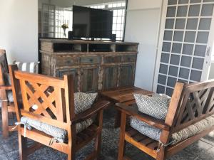 a living room with two chairs and a television at Hotel Sion in Monte Sião