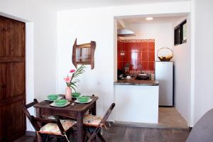 a kitchen and dining room with a table and a refrigerator at Casa Bagus in San Agustinillo
