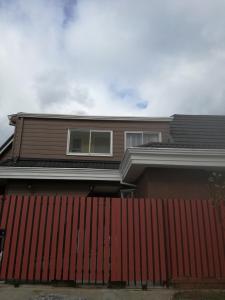 プエルトモントにあるCasa-Departamento Gimar Choroyの赤い柵の家