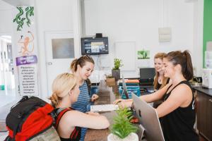 un grupo de mujeres de pie alrededor de un mostrador en Mad Monkey Central en Cairns