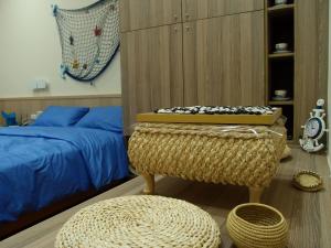 台南的住宿－基石民宿 ，一间卧室配有一张床、两张搁脚凳和一张卧床。