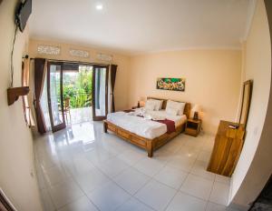 a bedroom with a bed and a large window at Pondok Bali in Ubud