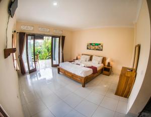 ein Schlafzimmer mit einem Bett und einem großen Fenster in der Unterkunft Pondok Bali in Ubud