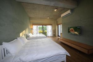 a bedroom with two beds and a tv on the wall at Country Living Home Stay in Jian