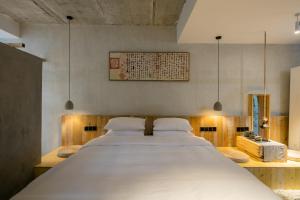 a bedroom with a large white bed in a room at Shangri-La Karesansui Hotel in Shangri-La