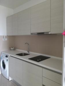 a kitchen with a sink and a washing machine at i-city i-soho in Shah Alam