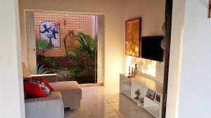a living room with a couch and a window at Casa da Praia in Guarajuba