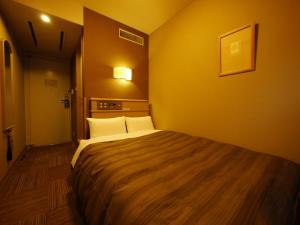 En eller flere senge i et værelse på Hotel Route-Inn Hakata Ekiminami